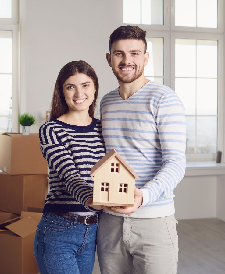 Couple Holding A Miniature House
